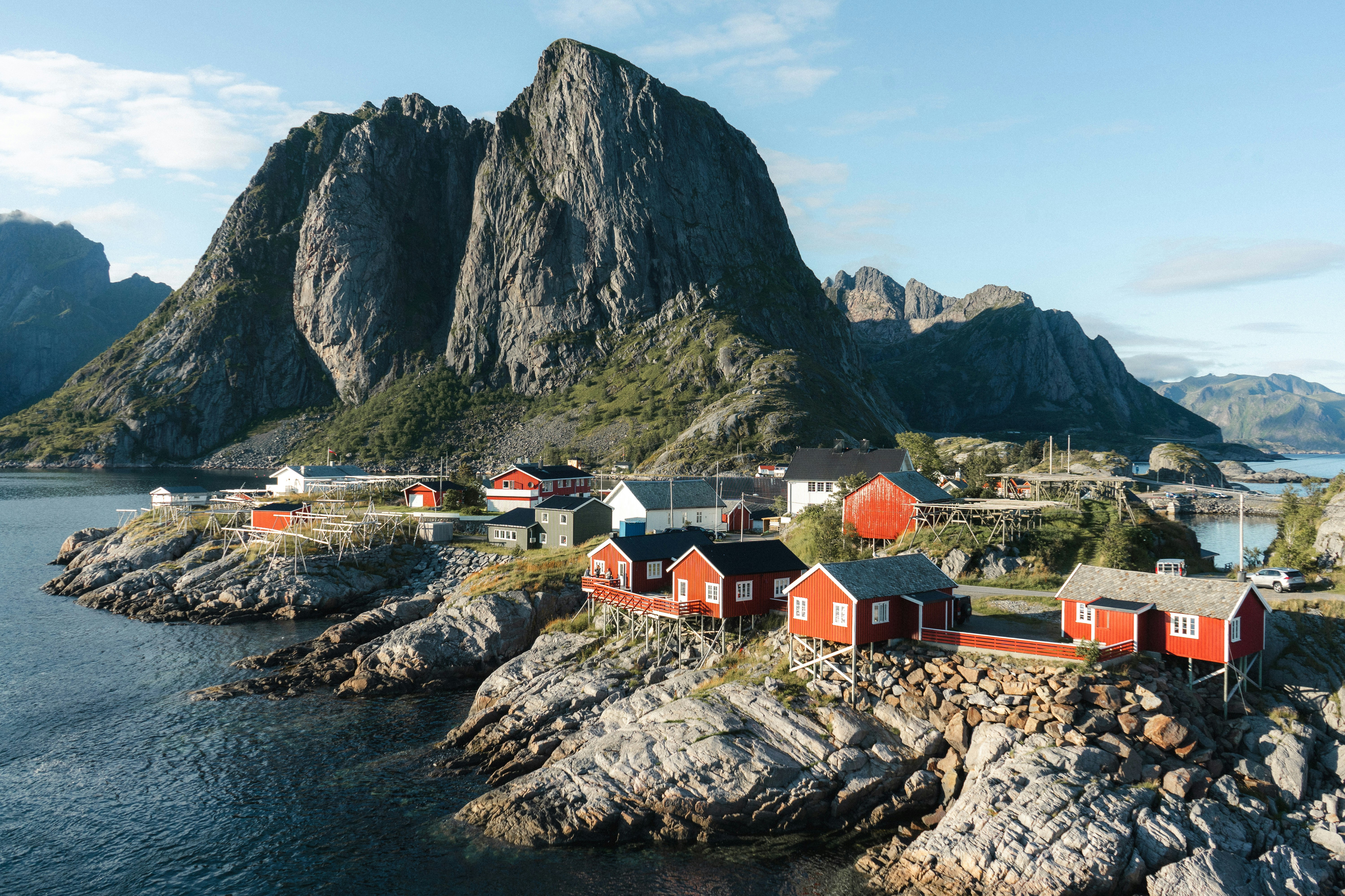 houses near mountain and body of water during daytime